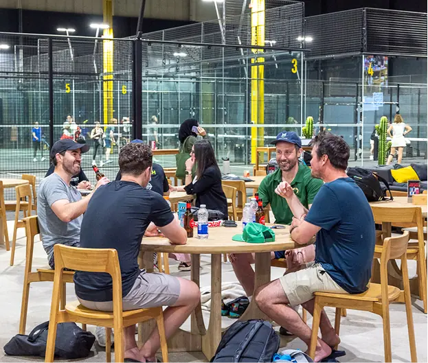 People socializing around a table at the court facilities